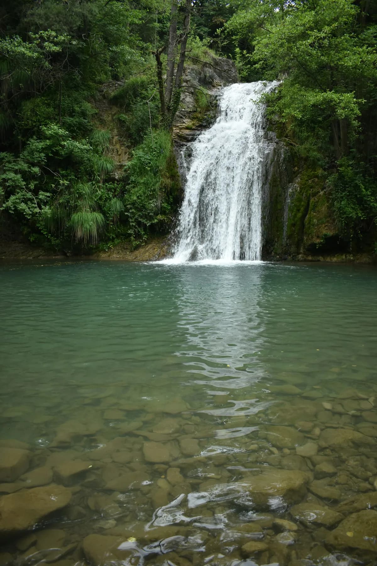 Sant Joan waterfall in the Catalan hills — clear green pool over limestone