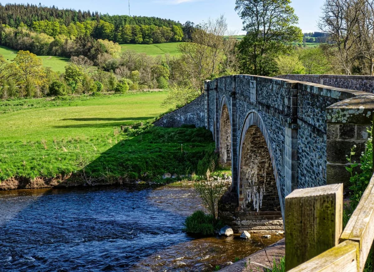 Stone bridge over the River Tweed in a green Borders valley