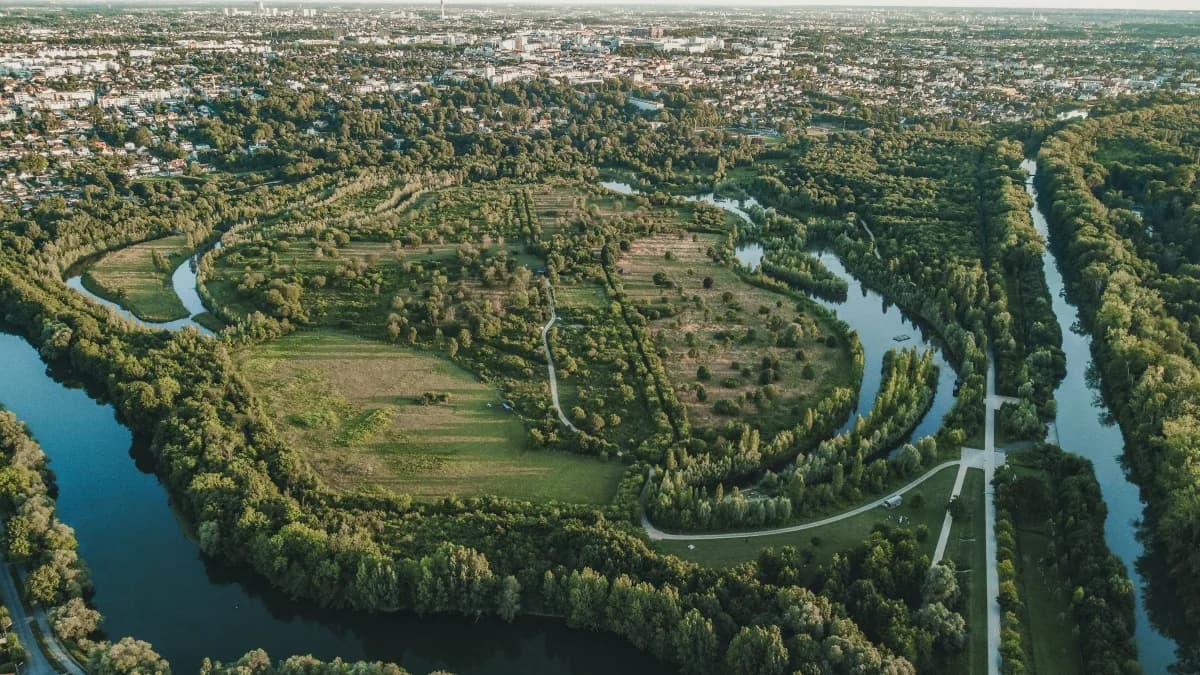 Aerial view of the Marne meandering around woodland with the Paris suburbs in the distance