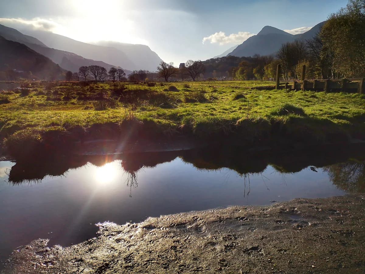 Llyn Padarn lake at Llanberis on a calm morning, with Snowdonia's mountains beyond the water.