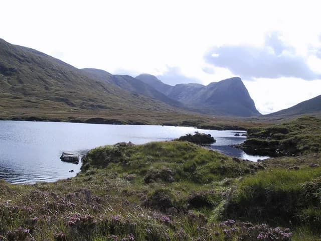 Loch Voshimid, a remote freshwater loch in North Harris, Outer Hebrides, with the hill of Sron Scourst rising behind the water.