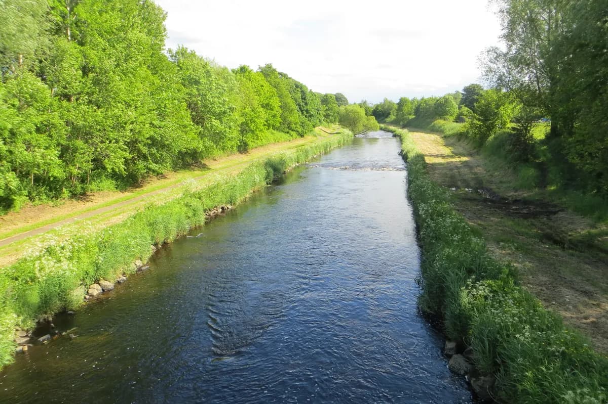 Wide view of the River Maine flowing through countryside near Ballymena, County Antrim, Northern Ireland.