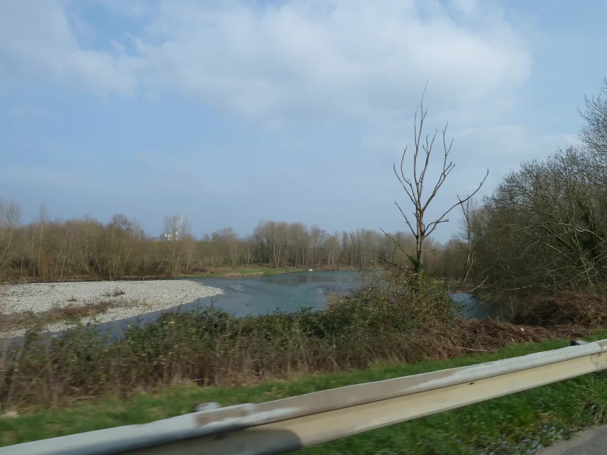 Wide view of the Gave de Pau river with gravel banks near Laroin in the Béarn region of France
