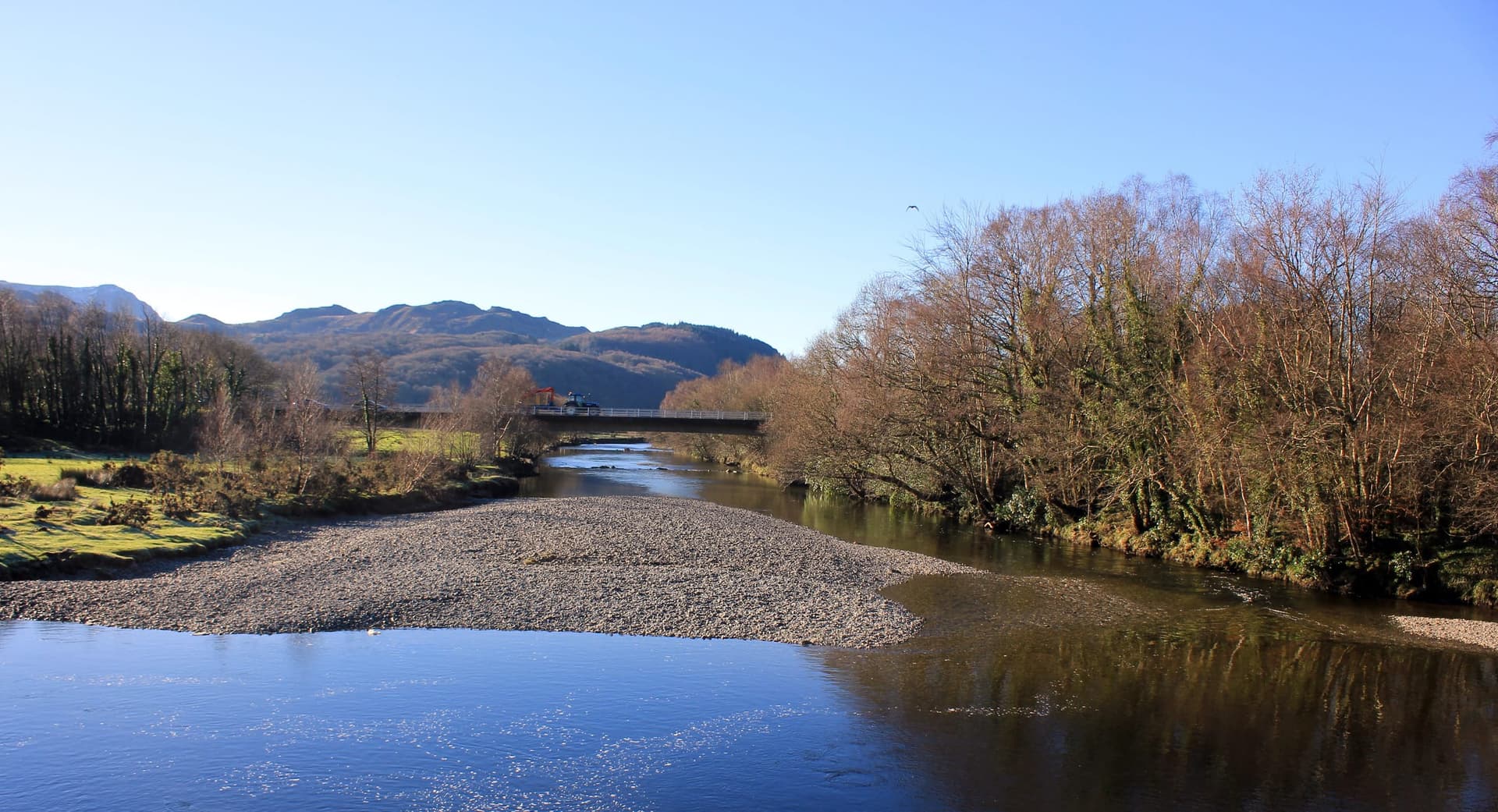 The Afon Mawddach flowing through the valley at Llanelltyd, looking upriver with wooded hillsides on the banks.
