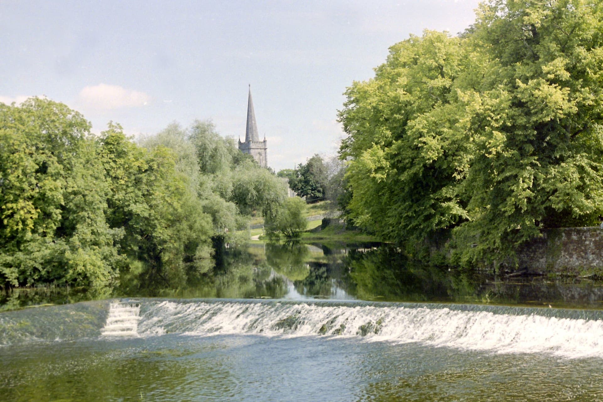 The weir on the River Suir at Cahir, turbulent water over the stone sill and calm pool below.